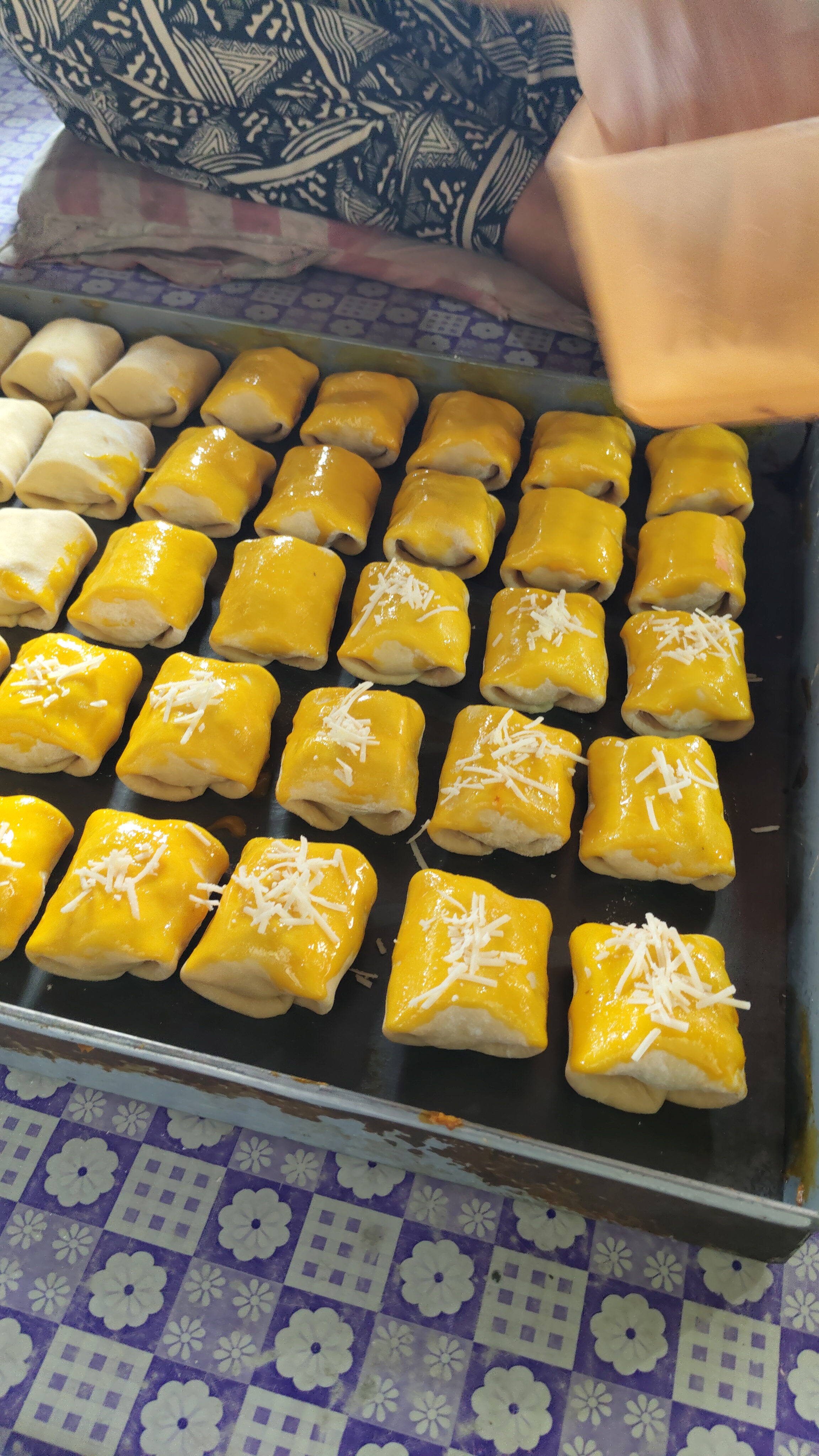 Proses menaburkan keju di atas adonan bolen